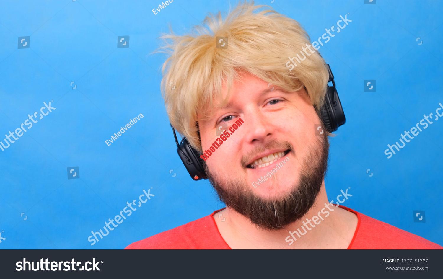 Discover the beauty of dating asian bbw - a unique and unforgettable experience stock photo freaky fat man in a wig and a pink t shirt in his hands listens to music on headphones and dances 1777151387